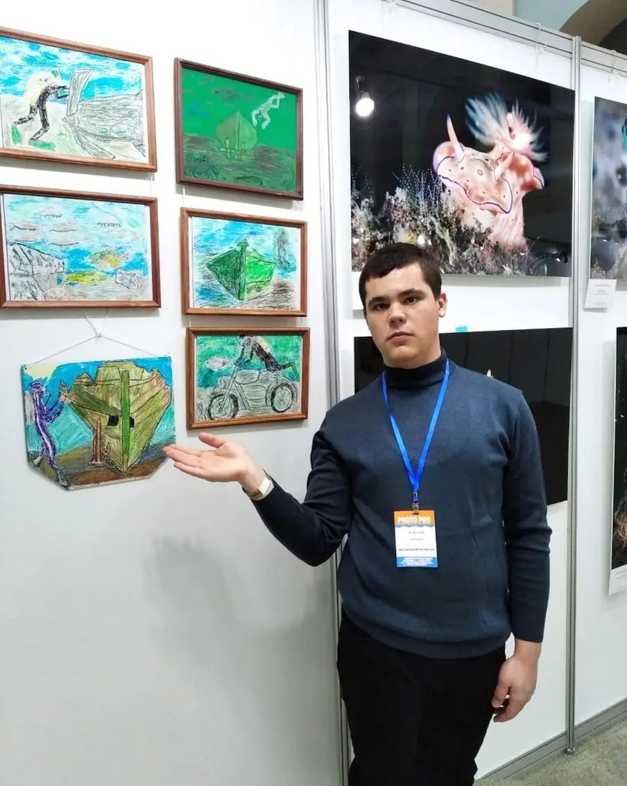 Никита Федотов рядом со своими работами в "Гостином дворе"